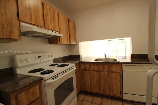 a kitchen with a stove a sink and a microwave