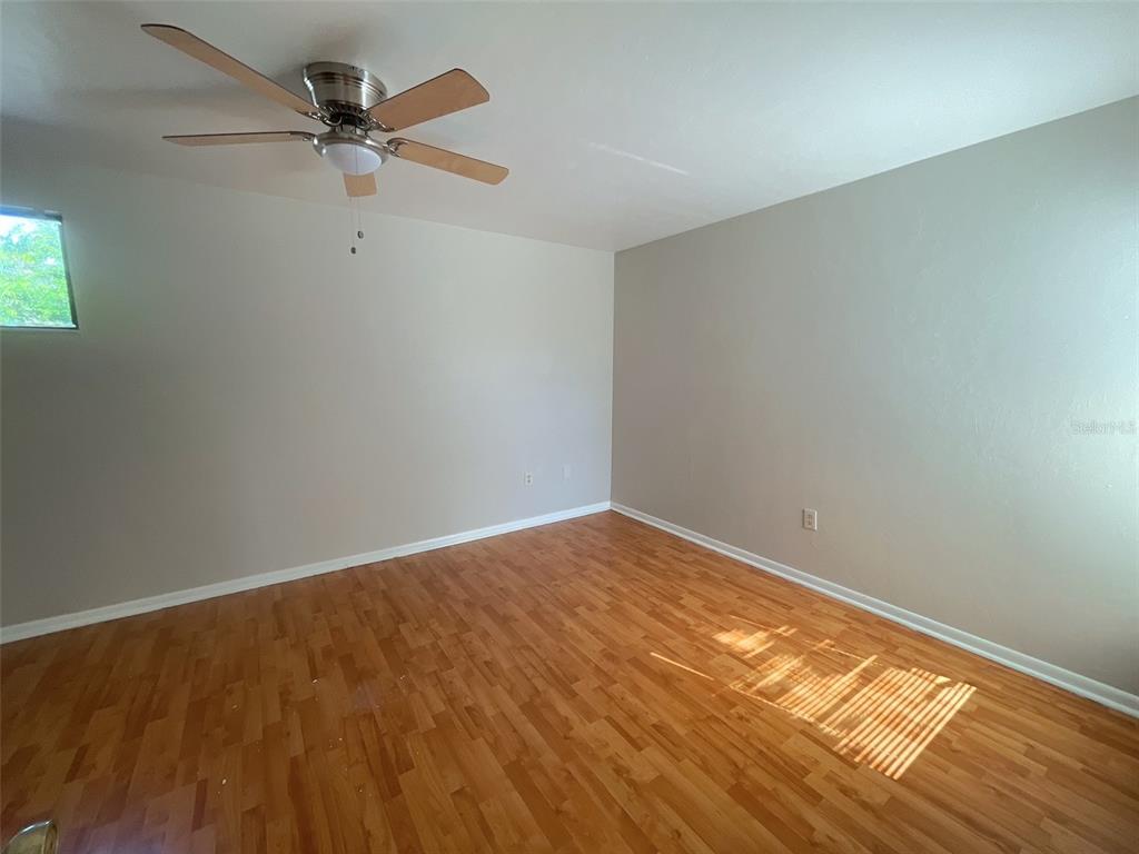 4345 Southwest 20th Lane, Unit 4345 Gainesville, FL 32607 - Photo 13 of 36 a view of a big room with wooden floor closet and ceiling fan