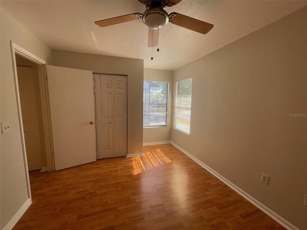 4345 Southwest 20th Lane, Unit 4345 Gainesville, FL 32607 - Photo 14 of 36 an empty room with wooden floor fan and windows