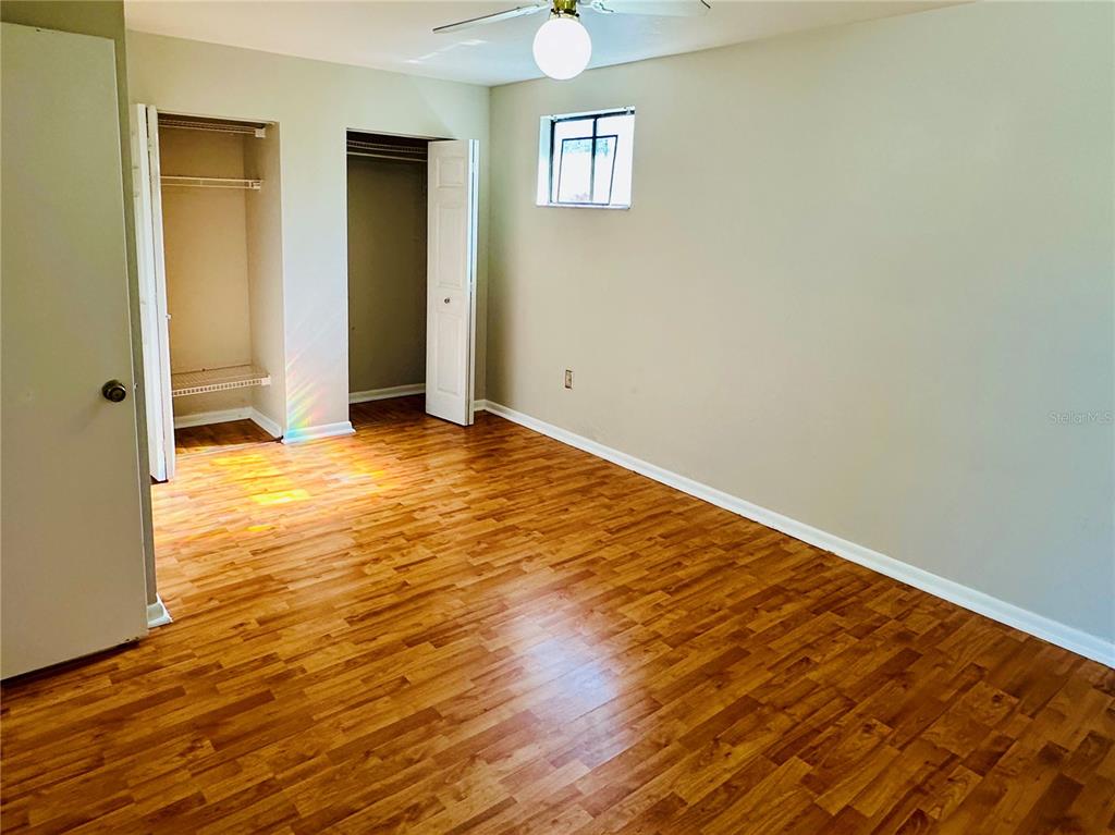 4345 Southwest 20th Lane, Unit 4345 Gainesville, FL 32607 - Photo 28 of 36 an empty room with wooden floor and windows
