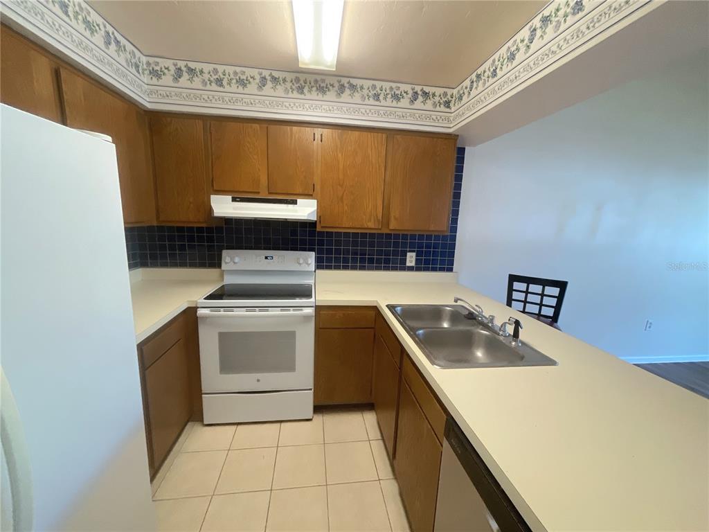4345 Southwest 20th Lane, Unit 4345 Gainesville, FL 32607 - Photo 8 of 36 a kitchen with a stove a sink and a refrigerator