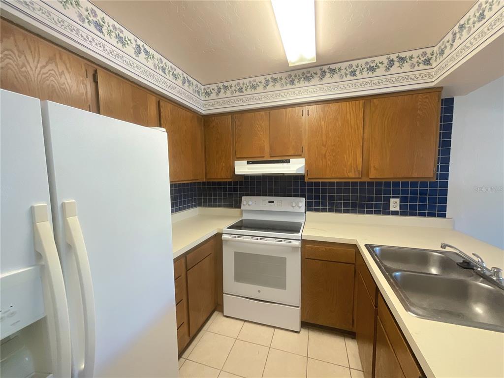 4345 Southwest 20th Lane, Unit 4345 Gainesville, FL 32607 - Photo 9 of 36 a kitchen with a stove a sink and a refrigerator