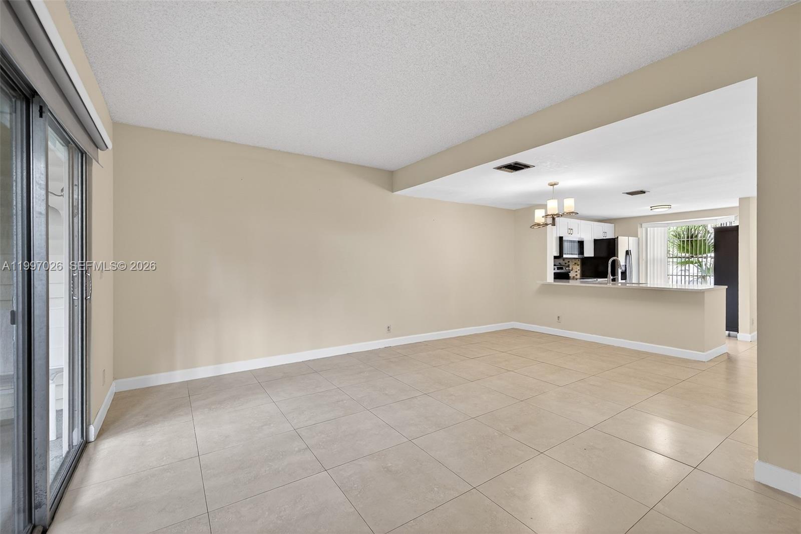 85 Southwest 3rd Street Pompano Beach, FL 33060 - Photo 15 of 29 an empty room with kitchen view and windows