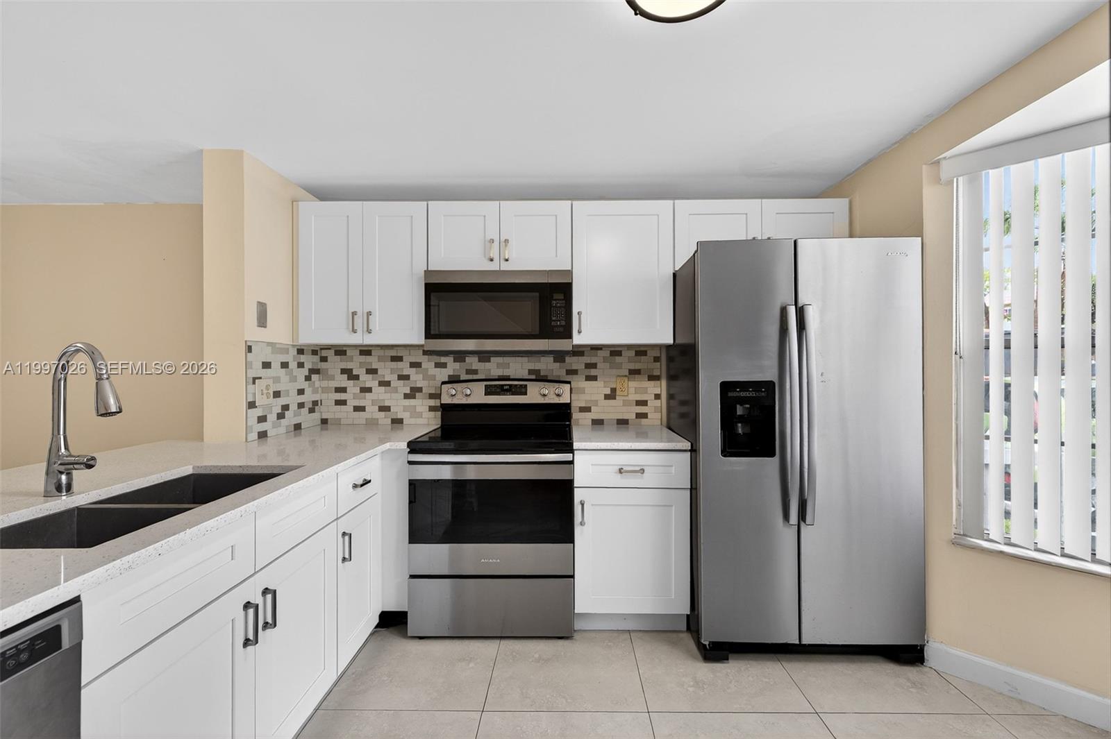 85 Southwest 3rd Street Pompano Beach, FL 33060 - Photo 8 of 29 a kitchen with white cabinets and stainless steel appliances