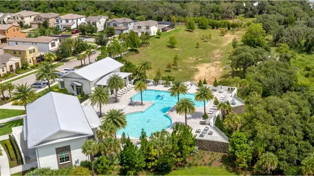 an aerial view of residential houses with outdoor space and trees