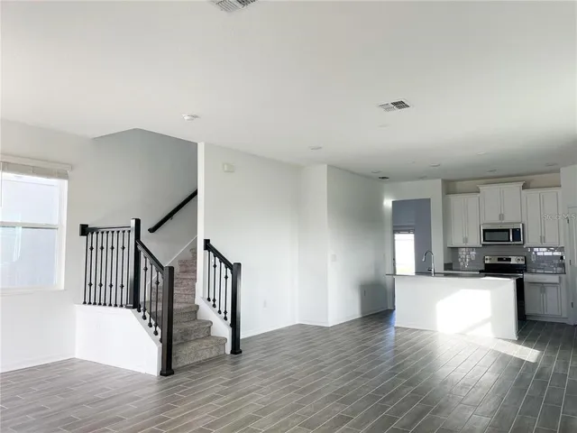 a view of a kitchen with wooden floor and electronic appliances