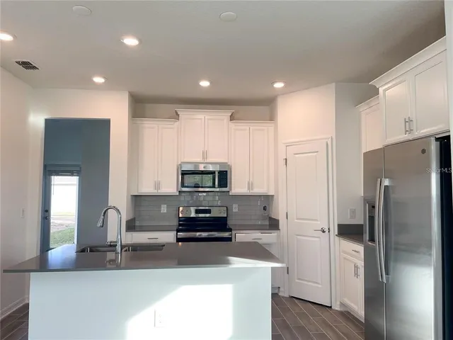a kitchen with stainless steel appliances a refrigerator sink and stove