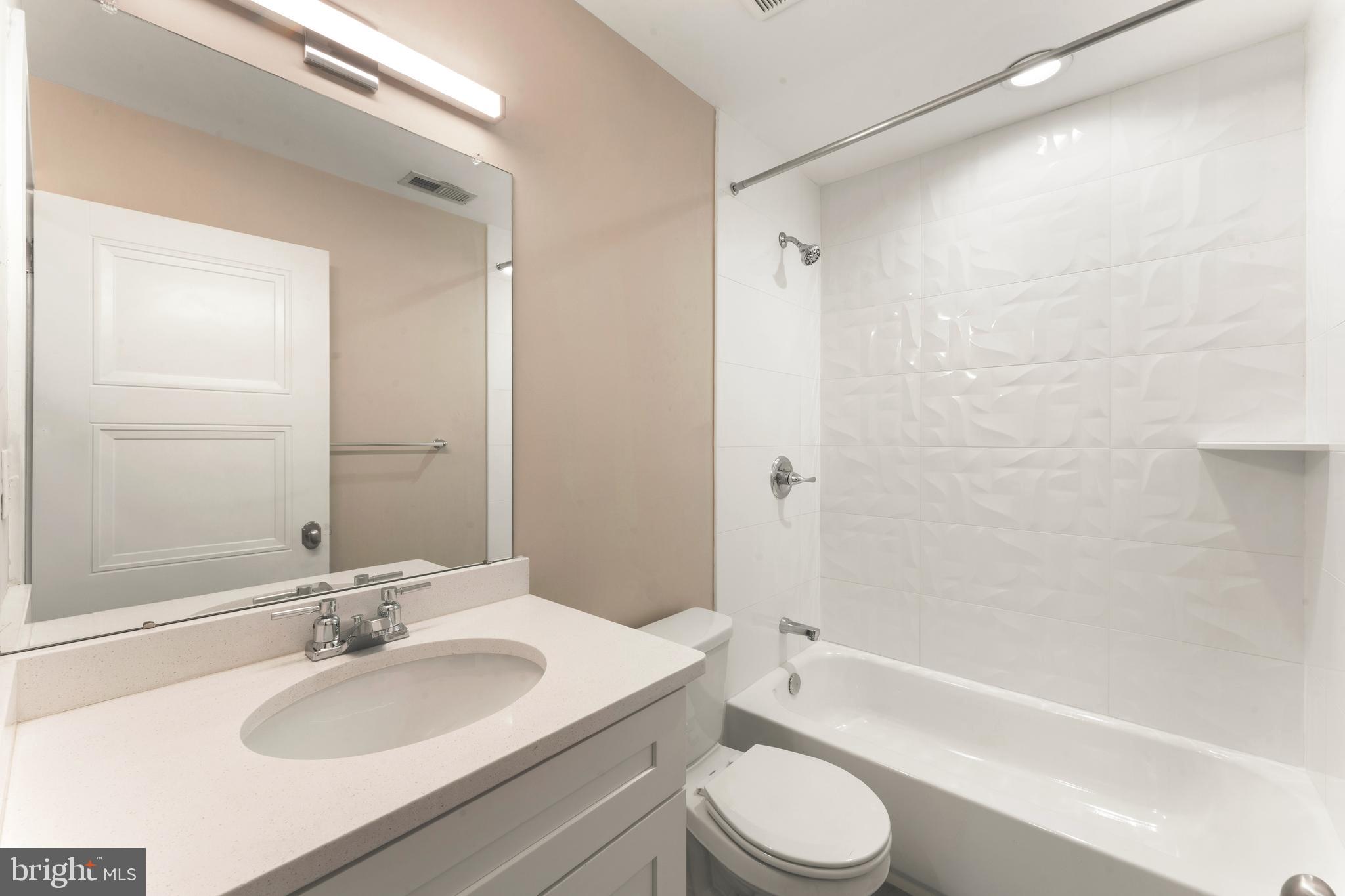 1407 North 8th Street, Unit A1 Philadelphia, PA 19122 - Photo 12 of 22 a bathroom with a sink toilet a bathtub and shower