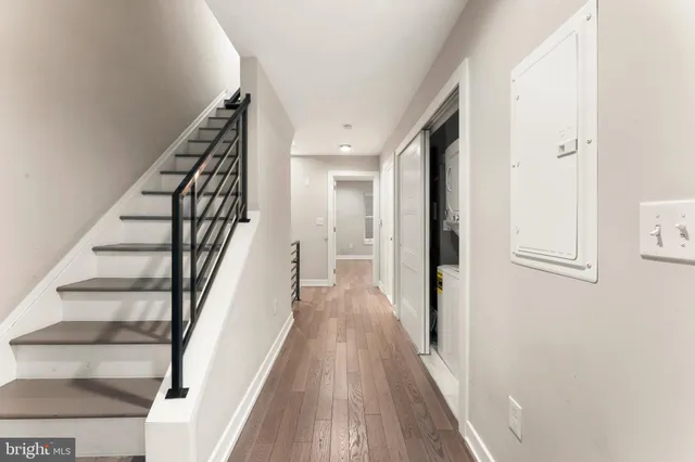 a view of a hallway with wooden floor and staircase