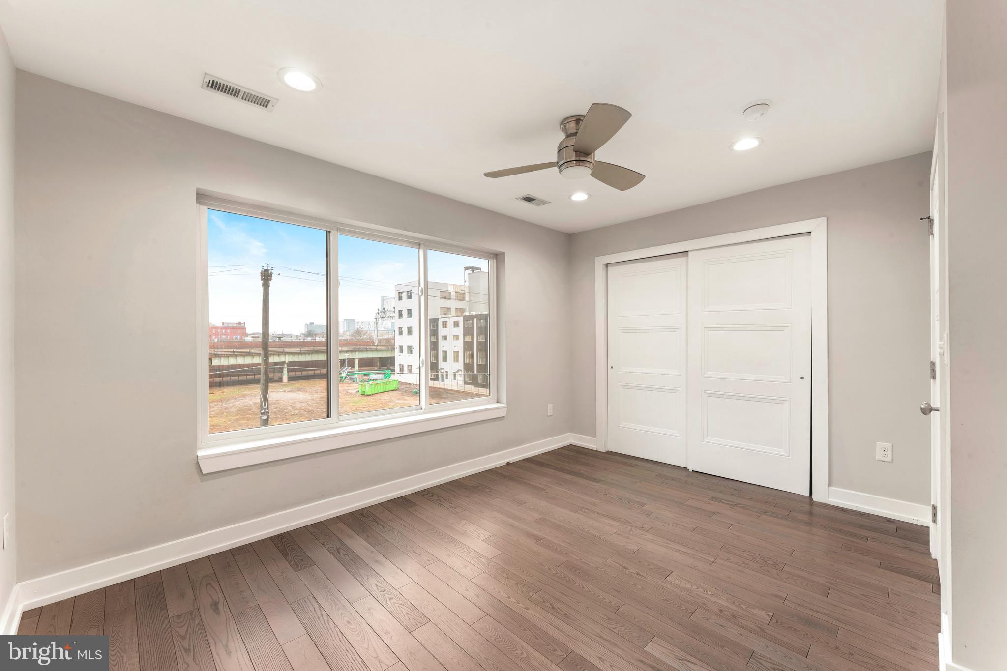 1407 North 8th Street, Unit A1 Philadelphia, PA 19122 - Photo 18 of 22 a view of an empty room with a window and wooden floor