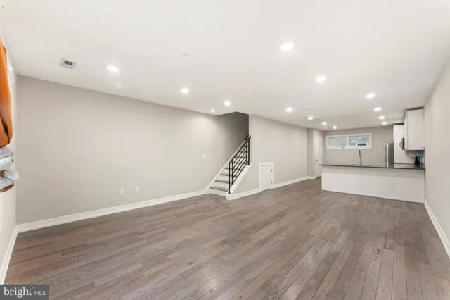 a view of an empty room with wooden floor