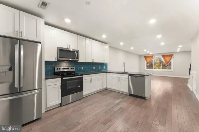 a large kitchen with a center island stainless steel appliances and cabinets