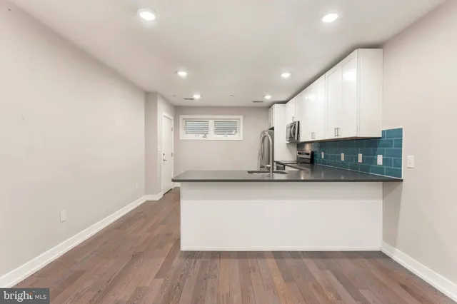 a view of kitchen with stainless steel appliances granite countertop a stove a sink and a microwave