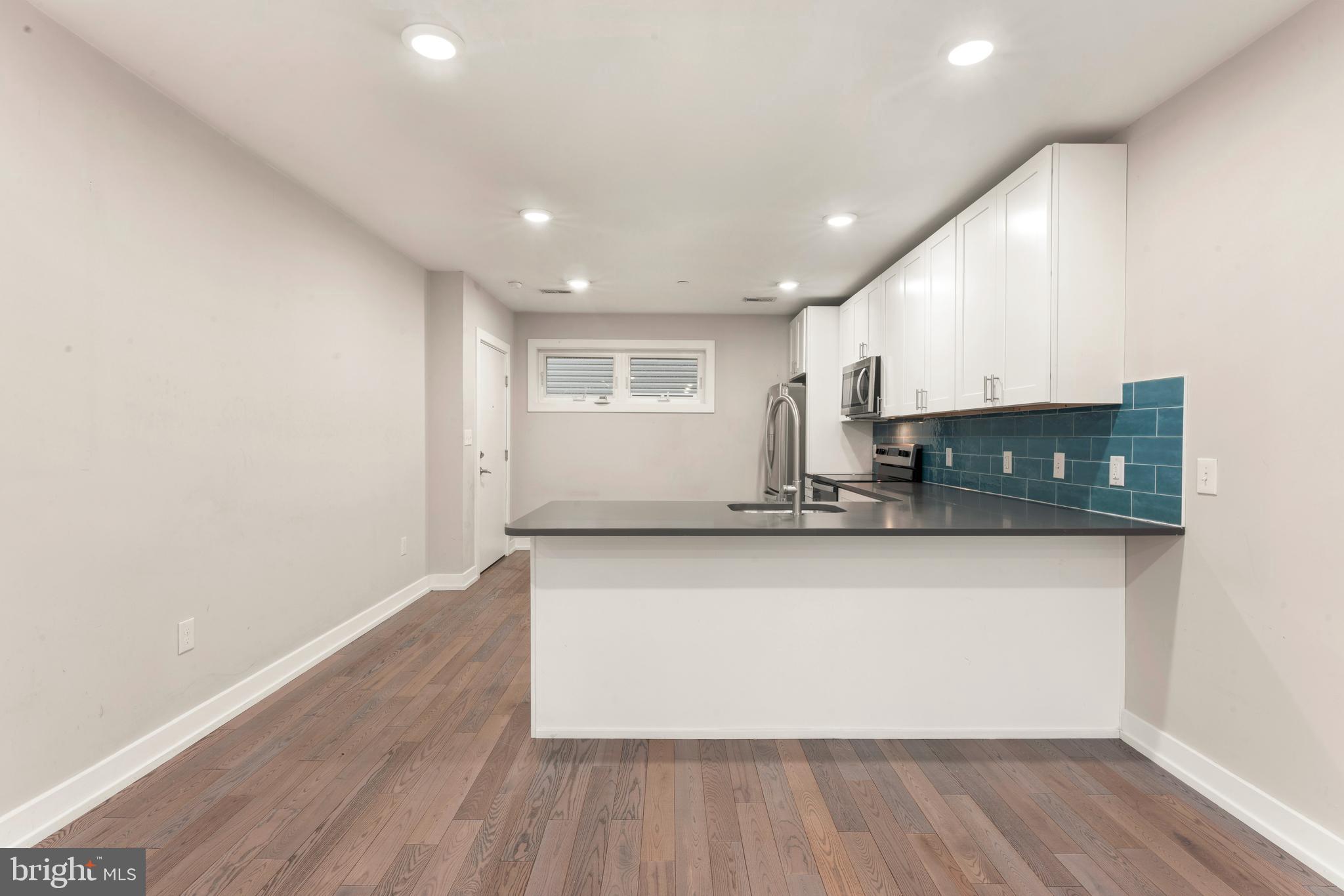 1407 North 8th Street, Unit A1 Philadelphia, PA 19122 - Photo 9 of 22 a view of kitchen with stainless steel appliances granite countertop a stove a sink and a microwave