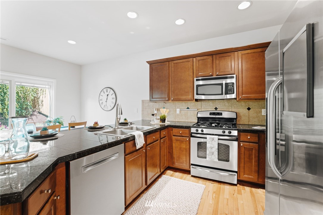 3007 182nd Place Southeast Bothell, WA 98012 - Photo 9 of 33 a kitchen with stainless steel appliances granite countertop a stove top oven a sink and dishwasher