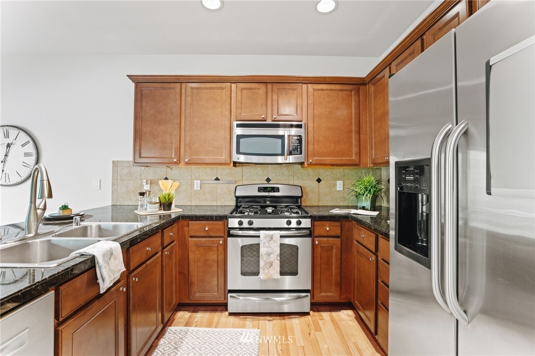 3007 182nd Place Southeast Bothell, WA 98012 - Photo 10 of 33 a kitchen with stainless steel appliances granite countertop a stove a sink and a refrigerator