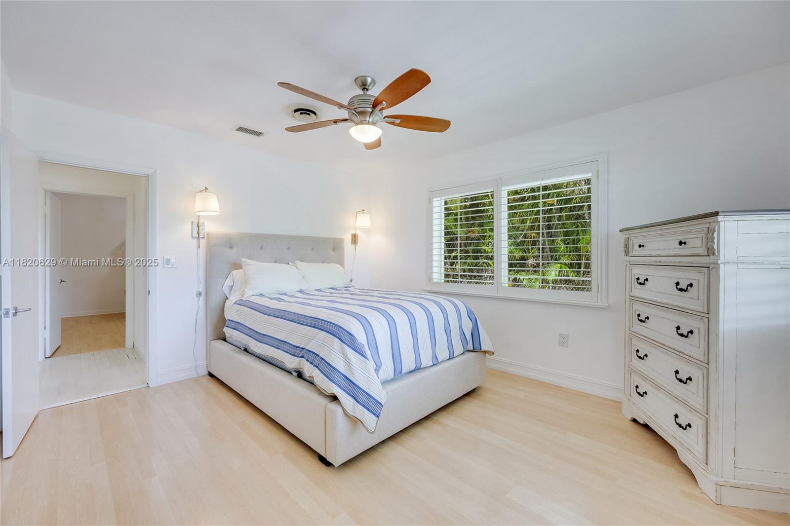 2085 Ixora Road North Miami, FL 33181 - Photo 11 of 28 a bedroom with a bed and a chandelier