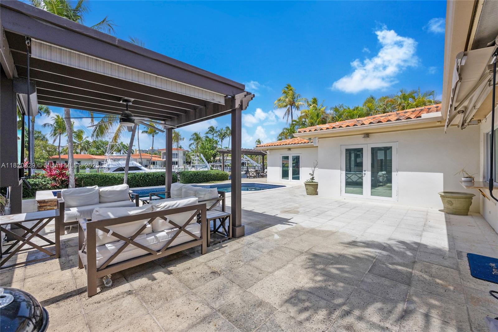 2085 Ixora Road North Miami, FL 33181 - Photo 17 of 28 a view of a patio with a table chairs and a backyard