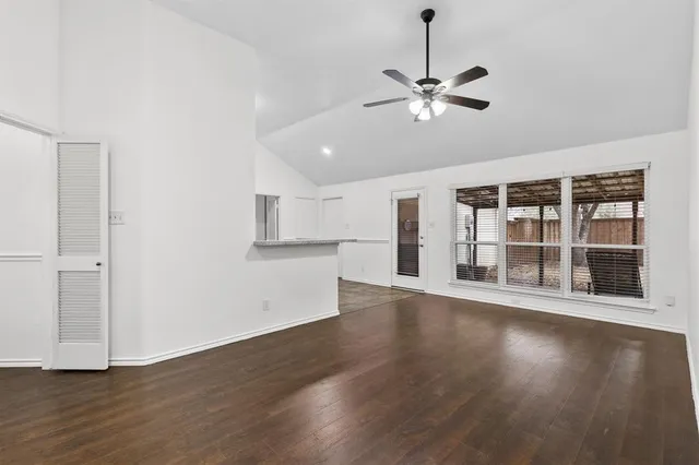 a view of a kitchen with wooden floor and a ceiling fan