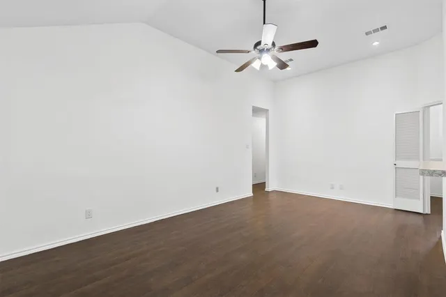 an empty room with a window and a ceiling fan