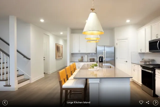 a large kitchen with a table chairs stove and refrigerator