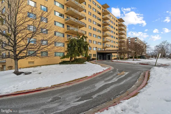 a view of a building with snow on the road