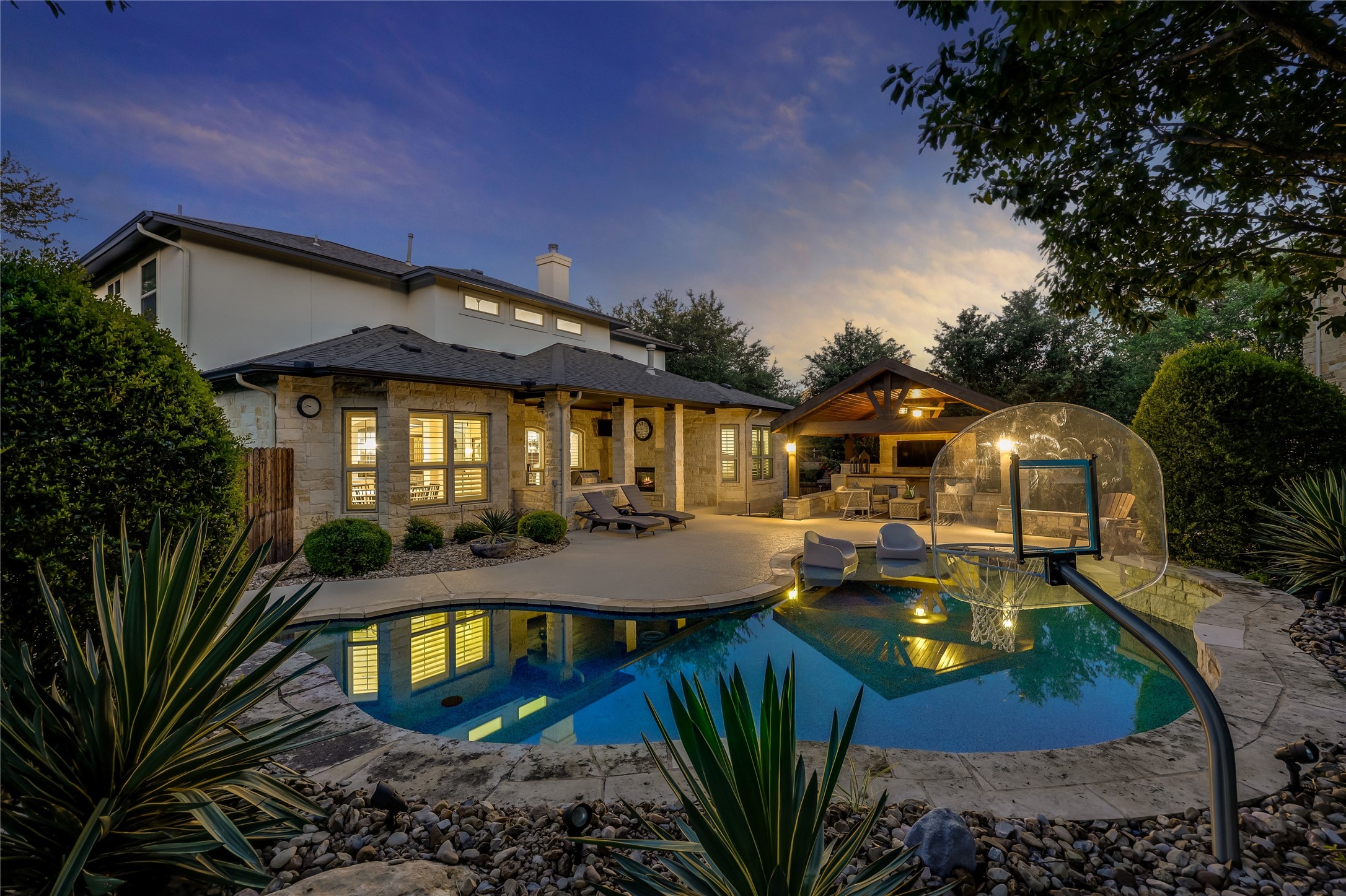 401 Bluff View Road Cedar Park, TX 78613 - Photo 17 of 40 An inviting backyard oasis offers a freeform pool, integrated spa, and a well-appointed outdoor kitchen, perfect for entertaining.