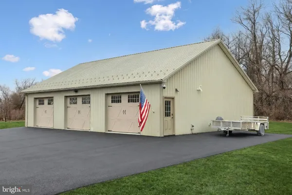 a bedroom with a large bed couch chandelier and a window