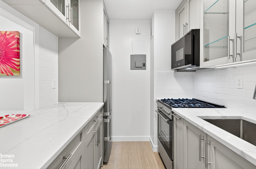 520 East 72nd Street, Unit 4J Manhattan, NY 10021 - Photo 6 of 15 a kitchen with stainless steel appliances granite countertop a sink stove and refrigerator