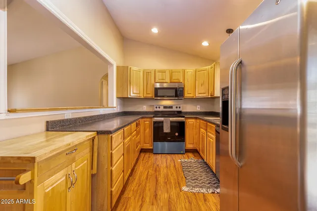 a kitchen with stainless steel appliances granite countertop a stove a sink and a refrigerator