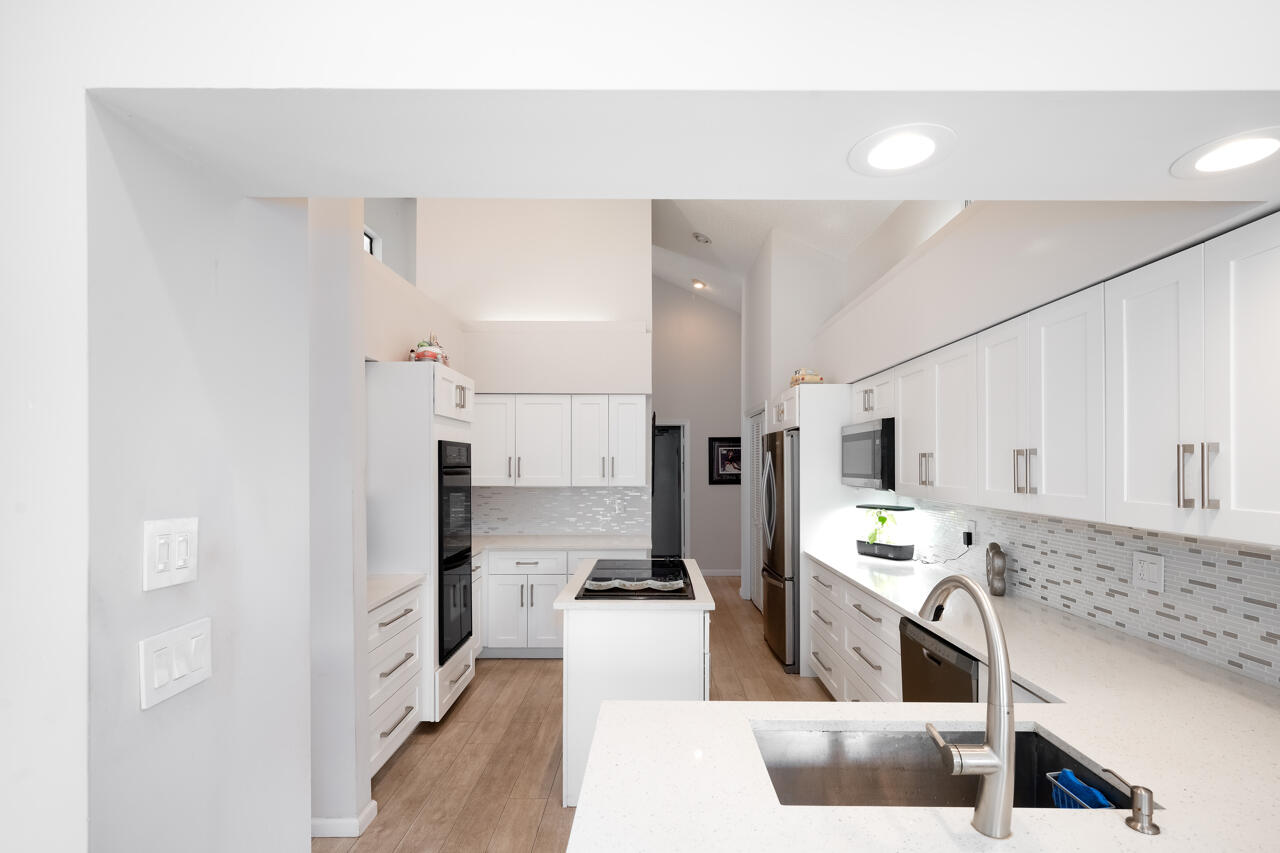 3740 Canterbury Way Boca Raton, FL 33434 - Photo 16 of 55 a kitchen with stainless steel appliances a refrigerator sink stove and cabinets
