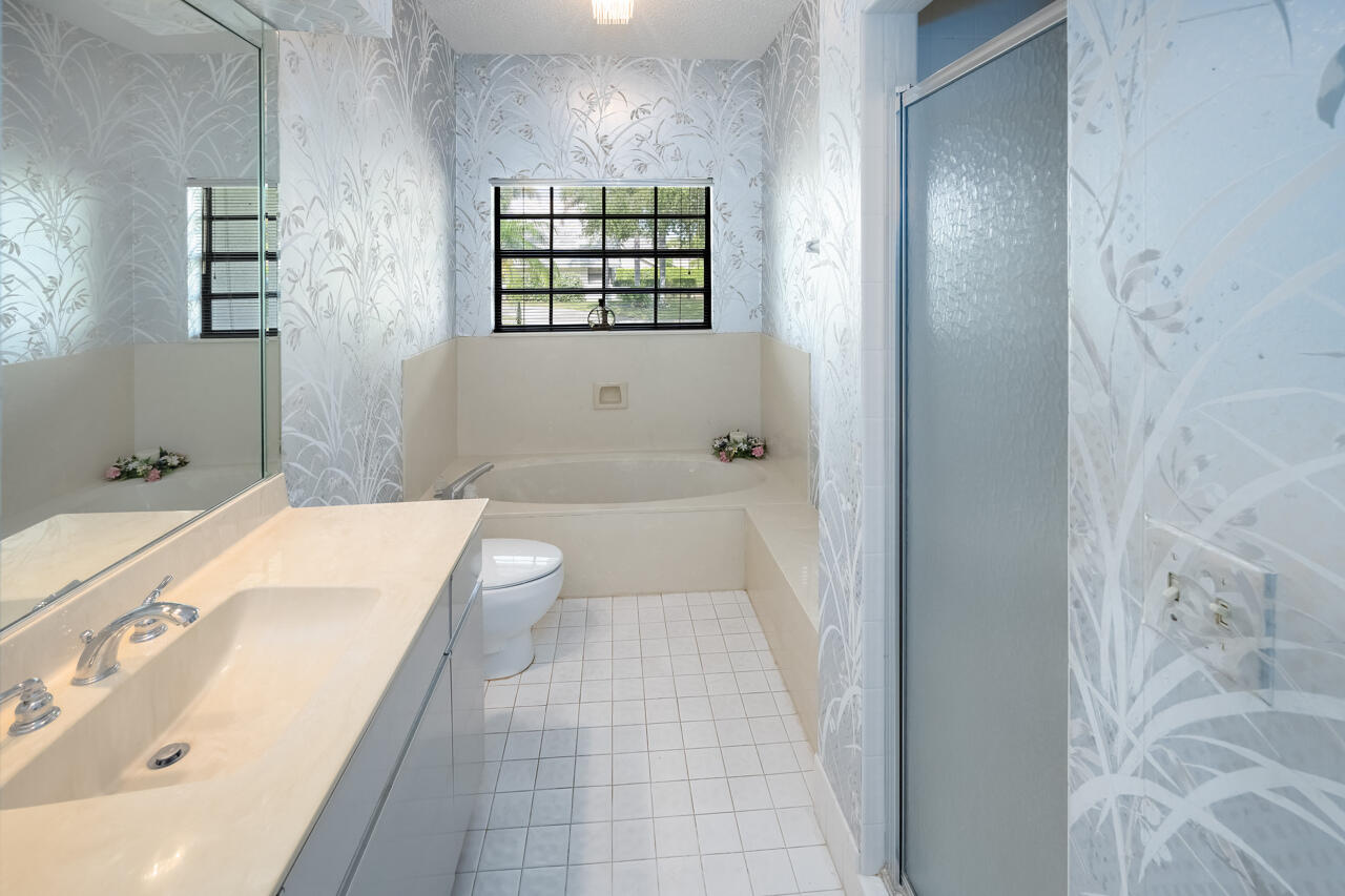 3740 Canterbury Way Boca Raton, FL 33434 - Photo 36 of 55 a bathroom with a tub a sink and a large mirror