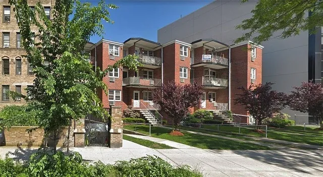 a front view of a house with a yard and a garden