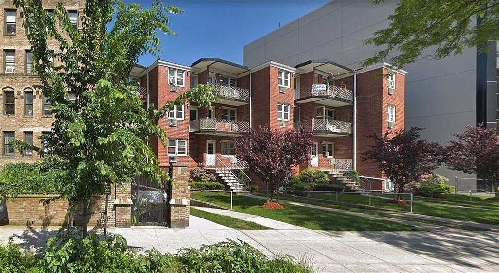 a front view of a house with a yard and a garden