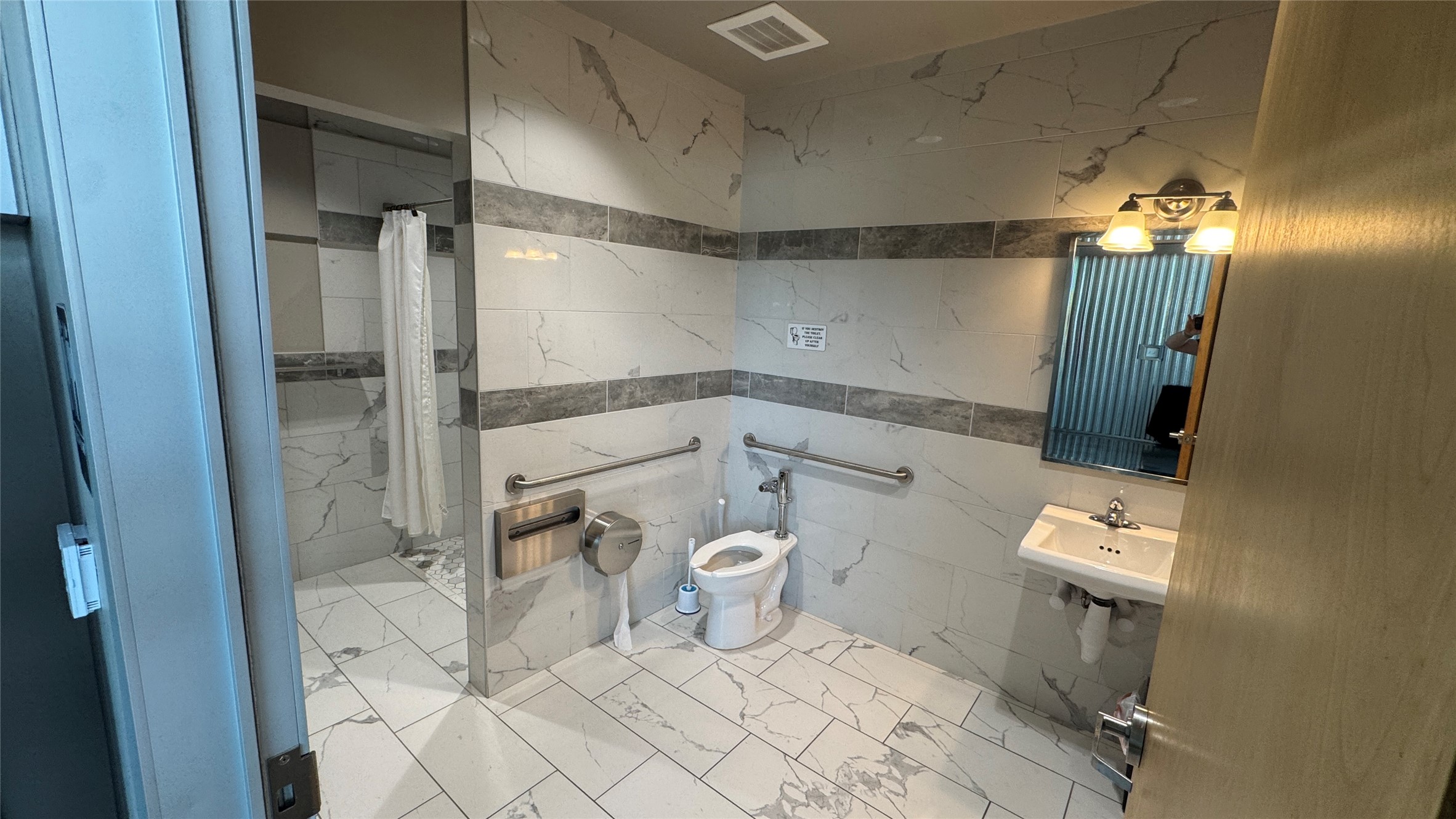 1009 Ranch Road 620 North, Unit 401 Lakeway, TX 78734 - Photo 14 of 15 A well-appointed accessible bathroom featuring a spacious shower and sleek tile work throughout.