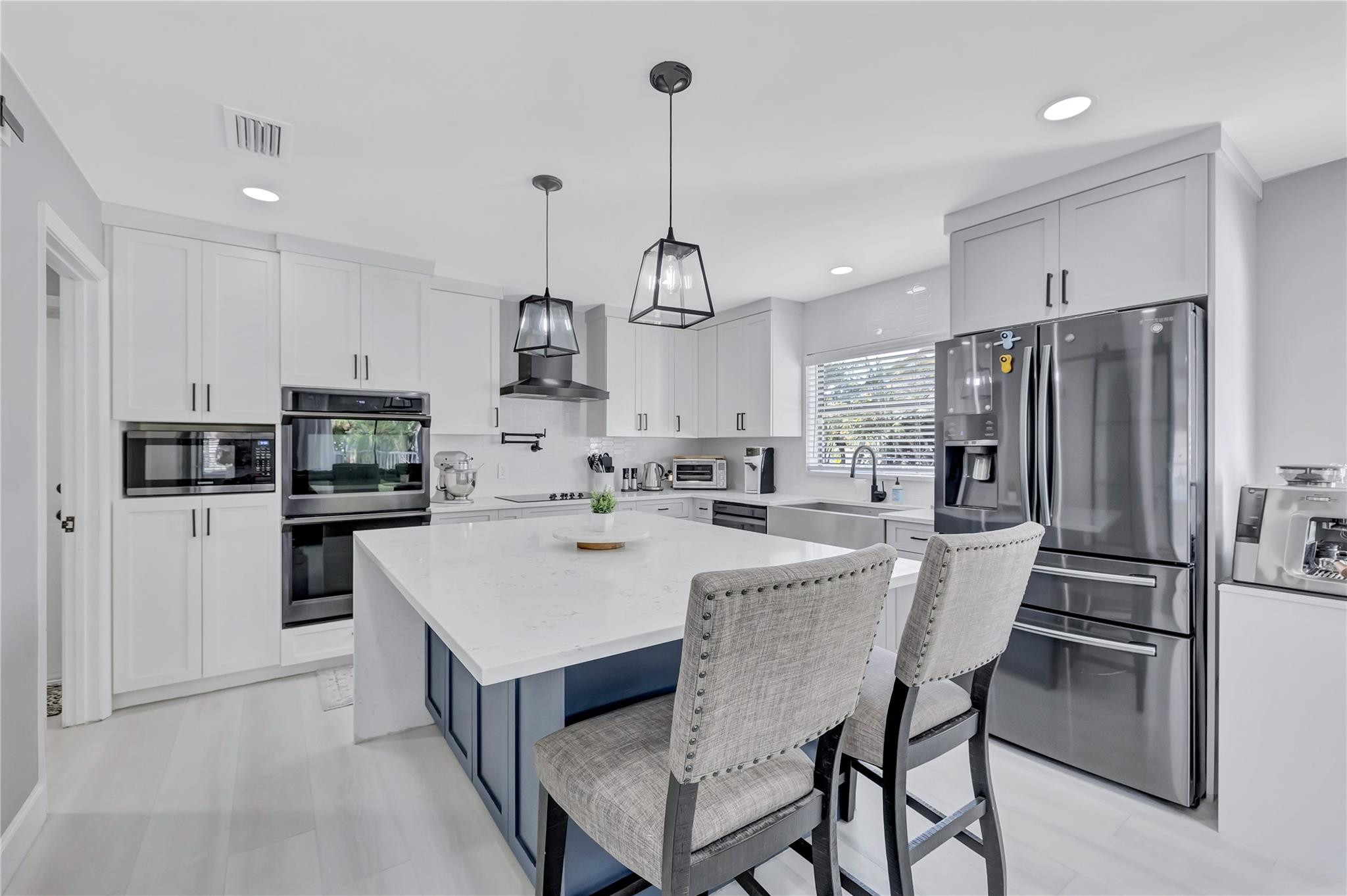 8613 Windy Circle Boynton Beach, FL 33472 - Photo 16 of 51 a kitchen with kitchen island a refrigerator a stove a sink and chairs