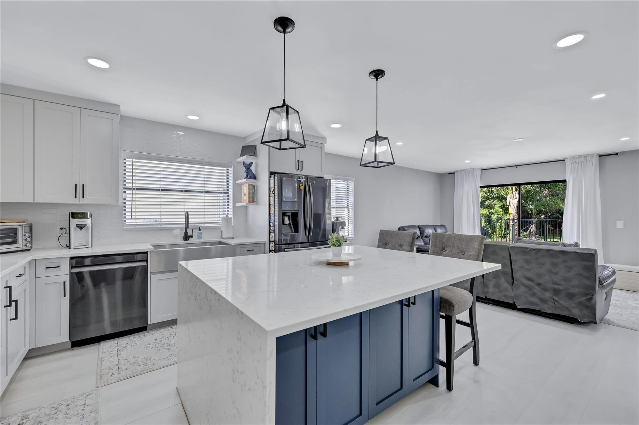 8613 Windy Circle Boynton Beach, FL 33472 - Photo 17 of 51 a large kitchen with sink a center island and stainless steel appliances