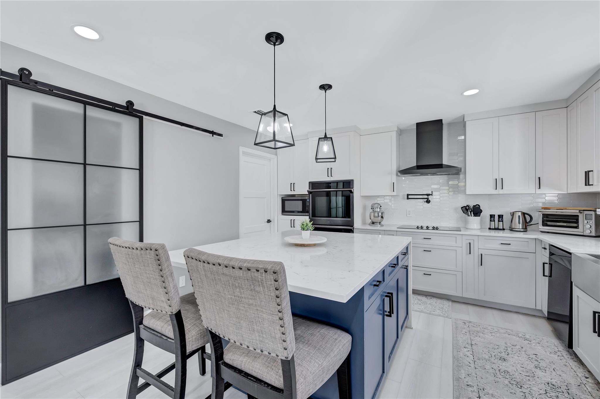 8613 Windy Circle Boynton Beach, FL 33472 - Photo 21 of 51 a kitchen with stainless steel appliances a table chairs and a refrigerator