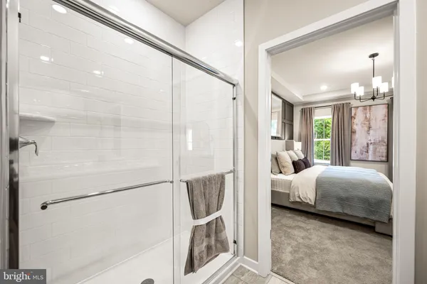 a en suite spacious bedroom with a bed and a chandelier