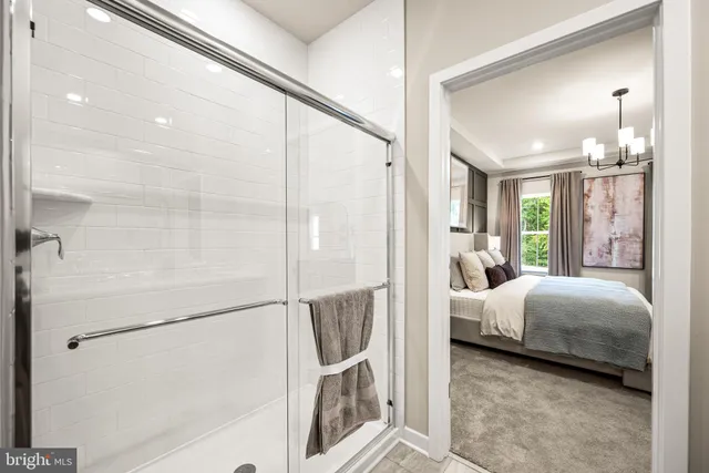 a en suite spacious bedroom with a bed and a chandelier