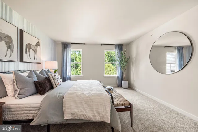 a bedroom with a bed a mirror and a window