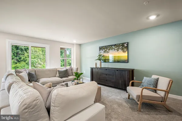 a living room with furniture a window and a flat screen tv
