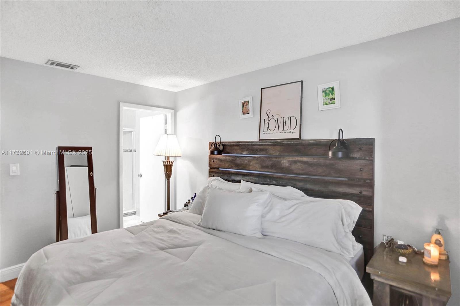 9395 Boca Cove Circle, Unit 1208 Boca Raton, FL 33428 - Photo 18 of 33 a bedroom with a bed and cabinet