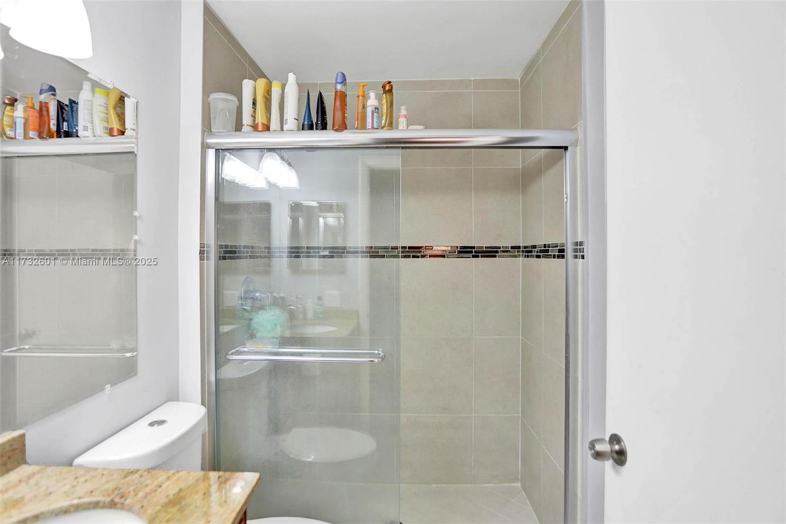 9395 Boca Cove Circle, Unit 1208 Boca Raton, FL 33428 - Photo 22 of 33 a bathroom with a bathtub and a shelf