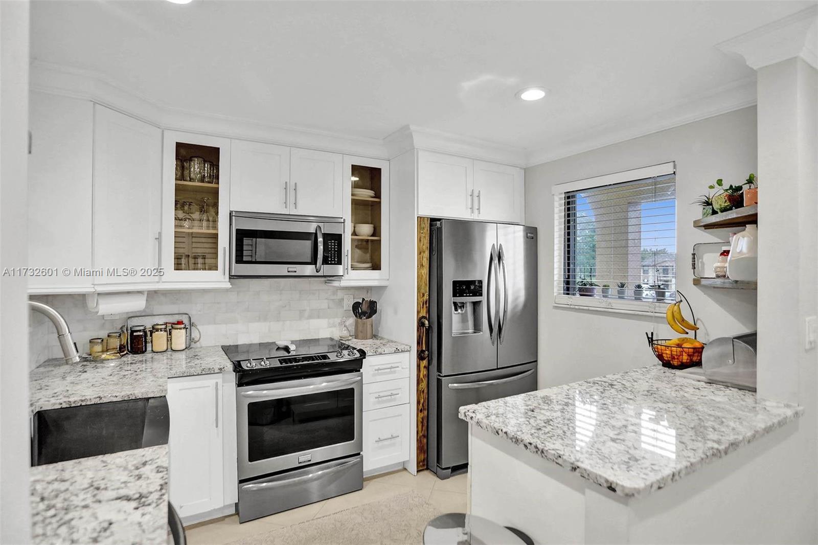 9395 Boca Cove Circle, Unit 1208 Boca Raton, FL 33428 - Photo 3 of 33 a kitchen with stainless steel appliances granite countertop a refrigerator and a stove top oven
