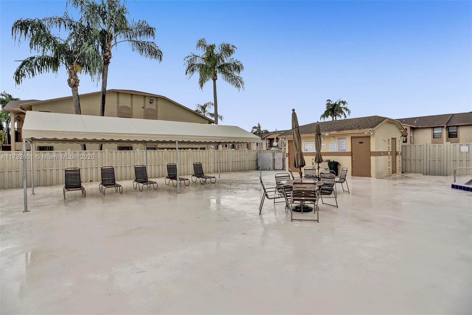 9395 Boca Cove Circle, Unit 1208 Boca Raton, FL 33428 - Photo 33 of 33 a view of a patio with a table and chairs under an umbrella