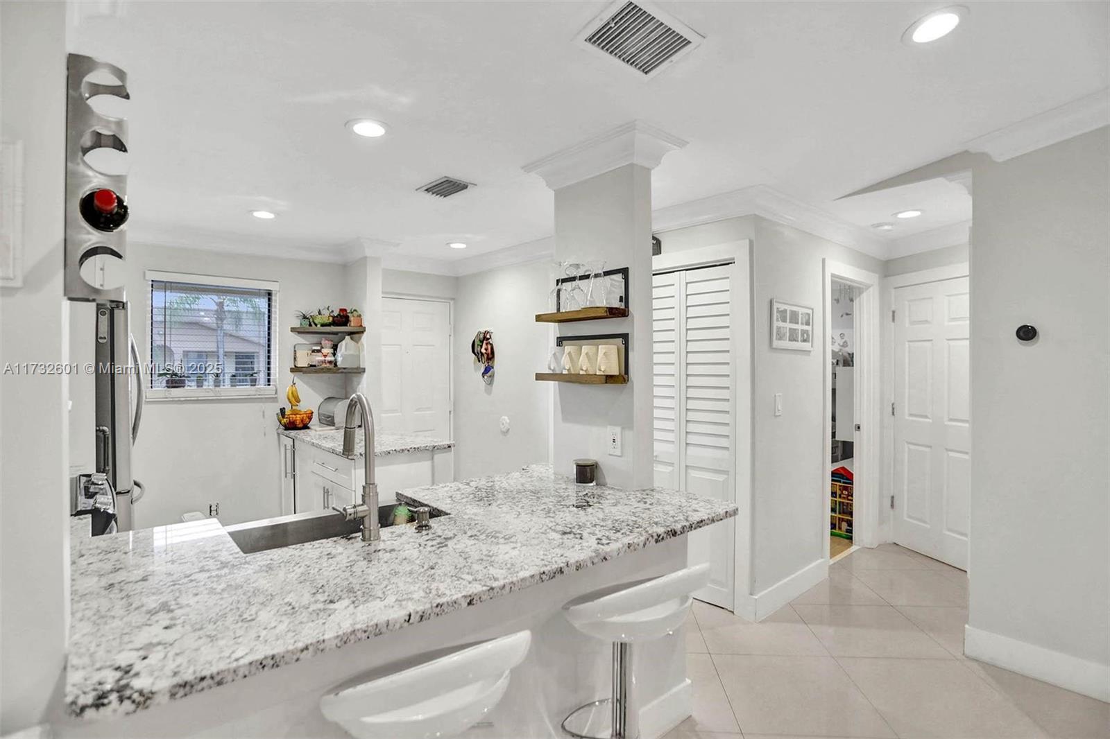 9395 Boca Cove Circle, Unit 1208 Boca Raton, FL 33428 - Photo 7 of 33 a kitchen with stainless steel appliances granite countertop a sink and a refrigerator