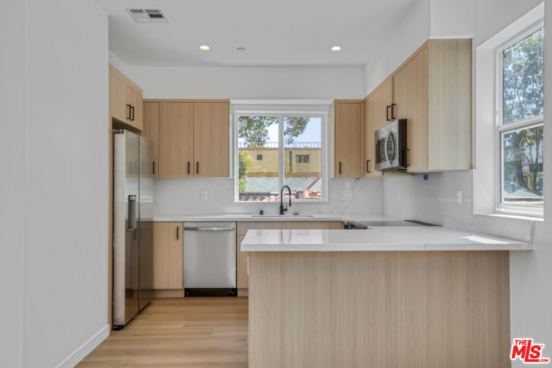 10828 Hesby Street North Hollywood, CA 91601 - Photo 10 of 33 a kitchen with stainless steel appliances granite countertop a sink and a granite counter tops