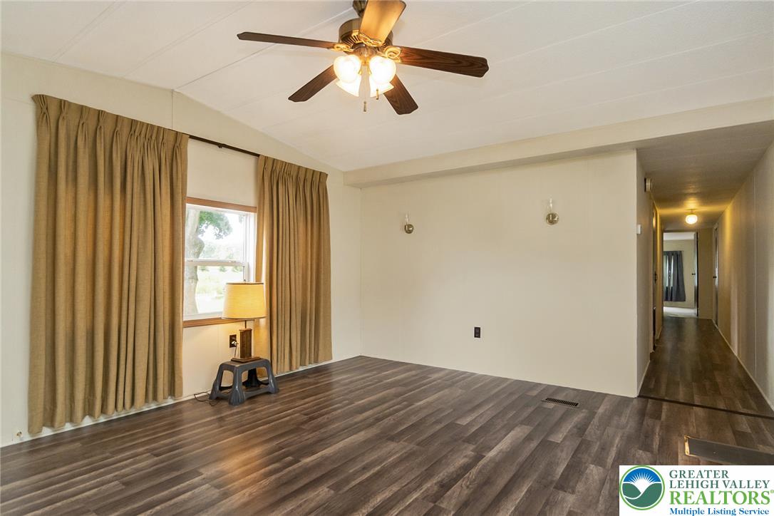 8721 Turkey Ridge Road Breinigsville, PA 18031 - Photo 6 of 30 Wood-look flooring runs throughout this open living space featuring a vaulted ceiling and window.