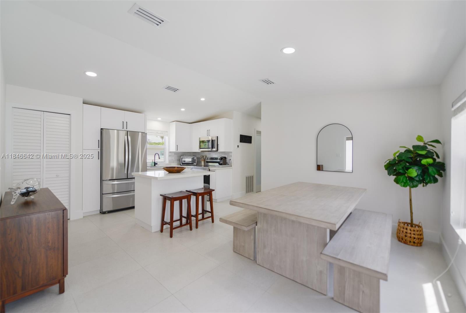 a kitchen with stainless steel appliances a refrigerator a sink a stove and white cabinets